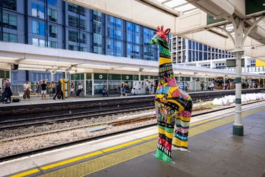 Croydon Stands Tall giraffes wait for a train at East Croydon station
