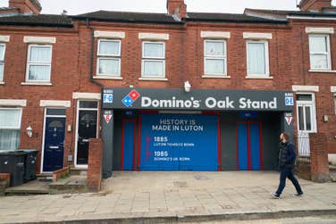 EDITORIAL USE ONLY A sign is installed at Luton Town F.C.’s Oak Stand entrance to the Kenilworth Road Stadium in Luton, renaming it as ‘The Domino’s Oak Stand’, ahead of the clubs first home Premier League game against West Ham United. Issue date: Friday September 1, 2023. PA Photo. The pizza chain, which opened its first UK store in Luton in 1985 is sponsoring the club's Oak Stand, to mark the brand's history in the town and the clubs rise to topflight football.