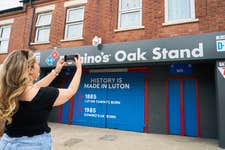 EDITORIAL USE ONLY A sign is installed at Luton Town F.C.’s Oak Stand entrance to the Kenilworth Road Stadium in Luton, renaming it as ‘The Domino’s Oak Stand’, ahead of the clubs first home Premier League game against West Ham United. Issue date: Friday September 1, 2023. PA Photo. The pizza chain, which opened its first UK store in Luton in 1985 is sponsoring the club's Oak Stand, to mark the brand's history in the town and the clubs rise to topflight football.