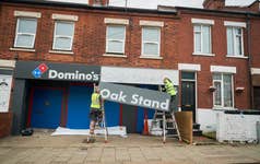 EDITORIAL USE ONLY A sign is installed at Luton Town F.C.’s Oak Stand entrance to the Kenilworth Road Stadium in Luton, renaming it as ‘The Domino’s Oak Stand’, ahead of the clubs first home Premier League game against West Ham United. Issue date: Friday September 1, 2023. PA Photo. The pizza chain, which opened its first UK store in Luton in 1985 is sponsoring the club's Oak Stand, to mark the brand's history in the town and the clubs rise to topflight football.