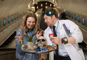 Maze Master, Samuel Hunt (left) with Cat Hajduk during ‘Maze on the Move’, a one-day immersive experience taking place between Charing Cross and Piccadilly Circus stations in London, featuring a 'Maze Master' unveiling puzzles to solve, with winners receiving free tickets to the Crystal Maze LIVE Experience. The Crystal Maze LIVE Experience offers an interactive adventure based on the 90s television show, located in London's West End.