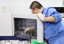 A researcher places a specimen in the ZSX Primus IV (Photo: Business Wire)