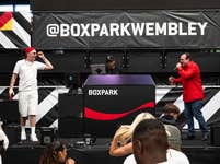 Aitch and Shaun Williamson perform Sweet Caroline on the Coca-Cola Zero Sugar stage at BOXPARK in Wembley ahead of England’s UEFA EURO 2024 game against Denmark. Picture date: Thursday June 20, 2024. PA Photo. New research from Coca-Cola Zero Sugar revealed that Sweet Caroline ranked the nation's favourite football anthem, above Three Lions and We Are The Champions.