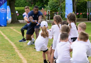 EDITORIAL USE ONLY ParalympicsGB canoeist, Rob Oliver (left) and Team GB sprinter and bobsledder, Joel Fearon participate in the tug of war against pupils from Thorns Infant School in Kenilworth, Warwickshire during a ÔPositive Energy Sports DayÕ, organised in partnership between British Gas and Heart Radio. Issue date: Tuesday July 2, 2024. PA Photo. Earlier this month, British Gas partnered with Heart Radio to run a radio competition, giving UK primary school pupils the opportunity to win a sports day for their school with Team GB and ParalympicsGB athletes at the three winning schools.