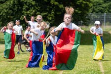 EDITORIAL USE ONLY Year 4 pupil, Flo participates in the sack race during a ‘Positive Energy Sports Day’, at St. Augustine's Catholic Primary School in Hythe, Kent, organised in partnership between British Gas and Heart Radio. Issue date: Tuesday July 2, 2024. PA Photo. Earlier this month, British Gas partnered with Heart Radio to run a radio competition, giving UK primary school pupils the opportunity to win a sports day for their school with Team GB and ParalympicsGB athletes at the three winning schools.