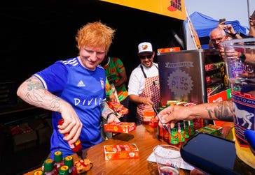 Ed Sheeran hands out ‘Handy Tingly Pies’, a new collaboration between Ed Sheeran’s hot sauce brand, Tingly Ted’s and Pieminister, which make their debut at today’s Ipswich Town Football Club home match against Liverpool, the first home match since the club’s recent promotion to the Premier League. Picture date: Saturday August 17, 2024. PA Photo. To mark Ipswich’s 203rd Premier League game (but its first for 22 years), 203 meat and 203 vegetarian ‘Handy Tingly Pie’ pies will be given away for free to fans during the fixture at Portman Road. Ed Sheeran is Ipswich Town Football Club’s headline sponsor, and has just announced a minority stake in the team.