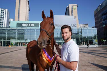 EDITORIAL USE ONLYTV personality Chris Hughes stands with racehorse Chase The Wind by a pop-up stable outside Media City in Salford to celebrate National Racehorse Week. Picture date: Friday September 6, 2024. PA Photo. National Racehorse Week is a nationwide annual celebration of the racehorse, with racing training yards, studs and aftercare centres across the country hosting variety of events.