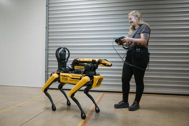 Pictures shows Rover the Boston Dynamics robot dog in JaguarLandrover Coventry facility. Pictured with handler Felicity.