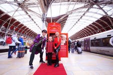 Joe Swash, dressed as Santa's Bellboy, poses with a festive red phone booth during the launch of the HeXmas Hotline at Paddington Station, London. The campaign, running from December 9-20, 2024, allows passengers to make festive calls to Santa and send holiday greetings before their journeys. Swash, who famously played a Bellboy as Mickey Miller in EastEnders, delighted fans by revisiting the role in this festive setting. Picture date: Monday, December 9, 2024.