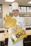 Kamran Taylor holding the trophy after winning the the Young Chef Olympiad (YCO), the world’s largest culinary competition for young chefs.