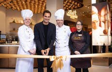 EDITORIAL USE ONLY Roger Federer, Lindt’s global ambassador, with master chocolatiers, Miquetta Veda De Castro (left) and Stefan Bruderer (second right), and store manager, Kayleigh Gigg (right) at the grand opening of the new Lindt flagship London store in Piccadilly Circus.