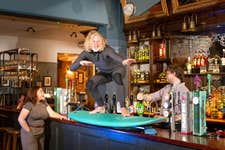 EDITORIAL USE ONLY Phil Owen from Surf Therapy, one of the grassroots sports clubs supported by Greene King IPA’s Proud to Pitch In scheme, stands on a surfboard on the bar at the Greene King Wig and Pen pub in Oxford. Issue date: Wednesday July 16, 2025. PA Photo. Since its launch in 2021, more than 370 teams have been supported by the Greene King IPA scheme, which gives clubs the opportunity to apply for funding for kit, equipment and venue hire, with £1 million in funding having been given to clubs across the UK. Research reveals one in four grassroots sports clubs is at risk of closure due to financial pressure.