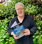 Author Dale Bradford, holding his novel, The Time-Travelling Estate Agent