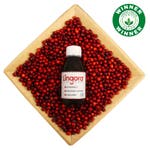A lingora bottle resting on a tray of lingonberries