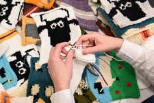 EDITORIAL USE ONLY A crafter creates a blanket from Shaun the Sheep-inspired knitted squares at the ‘Can Ewe Knit It’ workshop, celebrating Shaun the Sheep’s 30th birthday, at The Mills Fabrica in London, launched by Aardman with British Wool, Campaign for Wool and Craft Forward. Picture date: Tuesday October 28, 2025. PA Photo. The squares will be stitched together to form blankets to be donated to unhoused people through Craft Forward’s ‘Blankets for the London’ initiative.