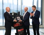 Powertrain International Editor-in-Chief Fabio Butturi (left) presents the Diesel Engine of the Year 2026 award to AGCO Power Vice President Juha Tervala. Next to them, AGCO Power Project Manager for Engineering Juha-Pekka Asikainen applauds. In the background: the CORE80 engine.