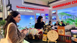 International visitor admires Huangshan cultural and creative exhibits at the Huangshan stand during ITB Berlin.