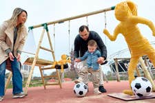 EDITORIAL USE ONLY Frank from Essex, age 3, who missed his formative park years while undergoing treatment for a brain tumour, with his mum Emily and dad Josh alongside replica chemotherapy‑wire sculptures installed at London’s Queen Elizabeth Olympic Park by Great Ormond Street Hospital Charity and created by Andy Goff to highlight the impact of rising childhood cancer diagnoses on families across the UK, as part of the charity’s mission to ensure every child has the best chance and best childhood possible. Picture date: Tuesday March 17, 2026. PA Photo.