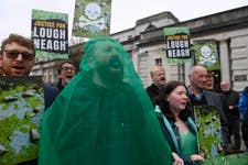 EDITORIAL USE ONLY Campaigners gather outside the Royal Courts of Justice in Belfast in support of eel fisherman Declan Conlon’s judicial review against the Department of Agriculture, Environment and Rural Affairs (DAERA), challenging its management of agricultural pollution in Lough Neagh. Picture date: Tuesday March 24, 2026. PA Photo. The lake, the largest in the United Kingdom and Ireland and a source of nearly half of Northern Ireland’s drinking water, has experienced repeated blue-green algal blooms and ecological decline, reportedly visible from space.