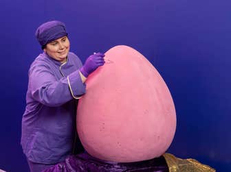EMBARGOED TO 0001 MONDAY MARCH 30 EDITORIAL USE ONLY Cadbury World Chocolatier Claire Fielding with the ‘Mega Mini Egg’, the world’s largest Cadbury Mini Egg, unveiled at Cadbury World in Birmingham. Issue date: Monday March 30, 2026. PA Photo. Handcrafted by chocolatiers Claire Fielding and Donna Pitts over two days, the egg stands at 70 centimetres tall and weighs 55kg, the same weight as an adult cheetah, and will be on display from March 30.