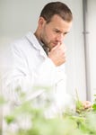 Bernard Blerot, VP R&D Naturals at IFF, smelling geranium in a botanical research laboratory.